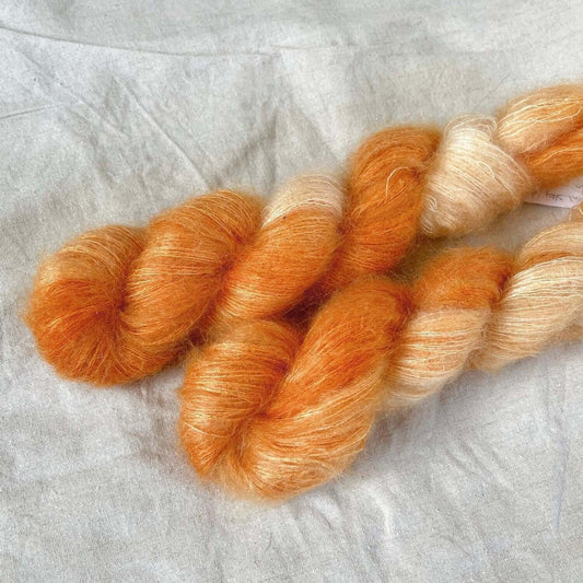 Potluck #25 (Orange Creamsicle). Melering av oransje. 2 hesper Silk Mohair (50g/420m). Eksempler til bruk 2 hesper (100g) holder til flere småplagg (eks. luer, votter, vesker), topper/singleter, genser til voksen opp til ca. str. M (eks. Sunday Swetaer fr